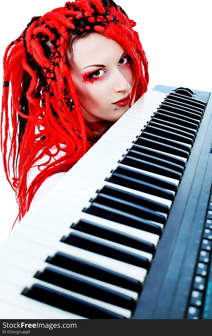 Rock musician is playing synthesizer. Shot in a studio.