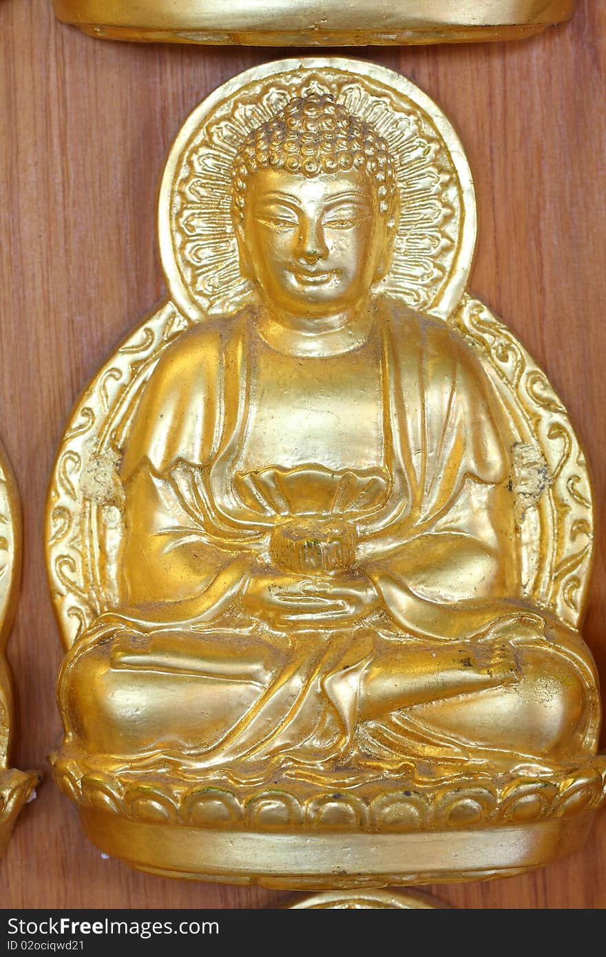 A gold buddha doll on the hard wood.