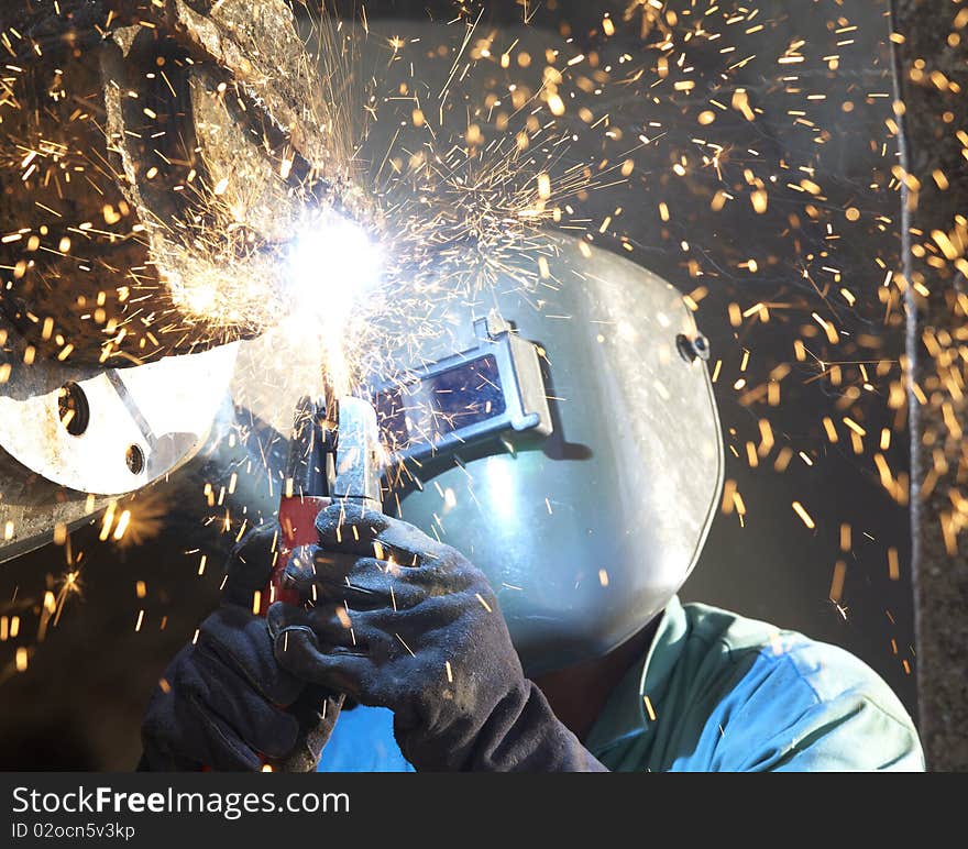 An arc welder working on a tub boat wheel. An arc welder working on a tub boat wheel