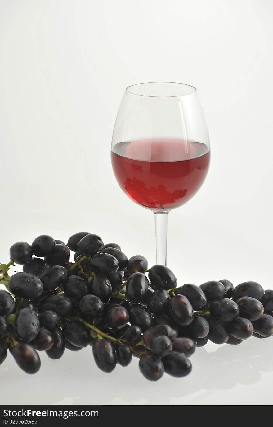 Red wine in a glass and red grape. Red wine in a glass and red grape.