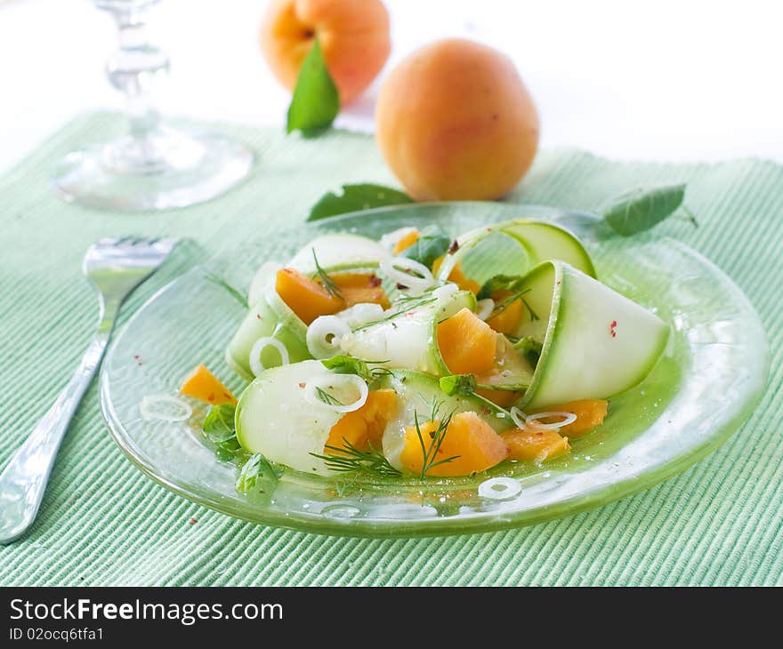 Appetizer with zucchini and apricots, garnish with basil and onion on glass plate. Appetizer with zucchini and apricots, garnish with basil and onion on glass plate