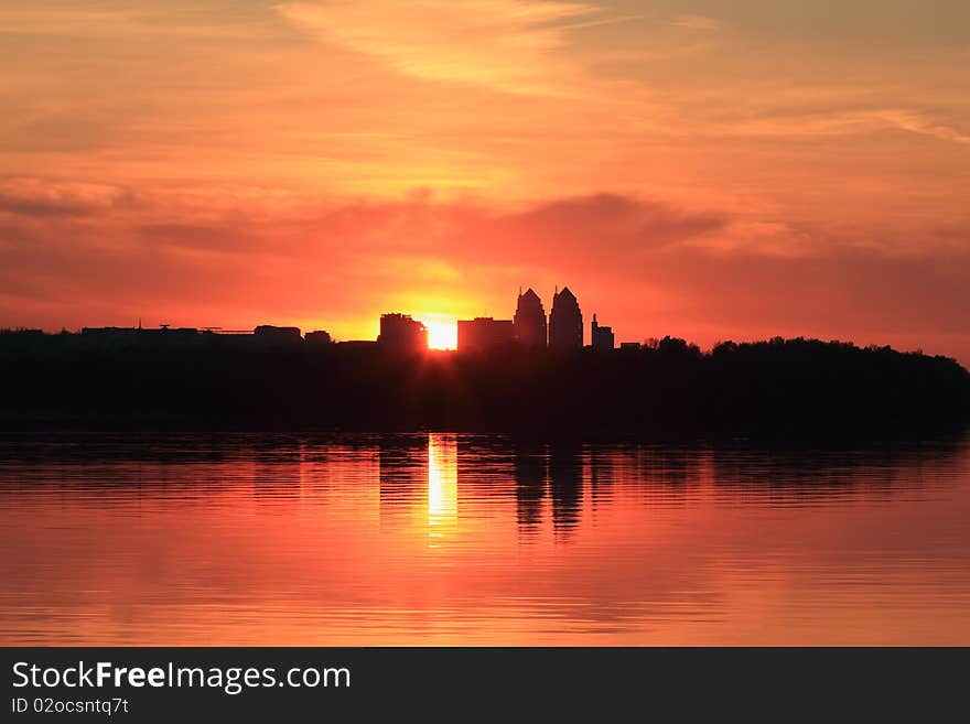 Cityscape of sunset scenery with building silhouette and river reflection. Cityscape of sunset scenery with building silhouette and river reflection