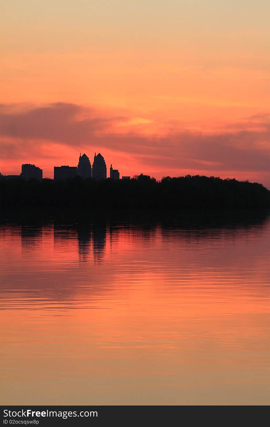 Cityscape of sunset scenery with building silhouette and river reflection. Cityscape of sunset scenery with building silhouette and river reflection