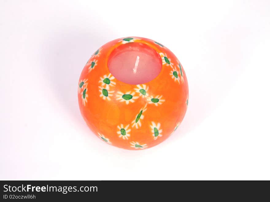 Spherical unlit orange candle with flower design