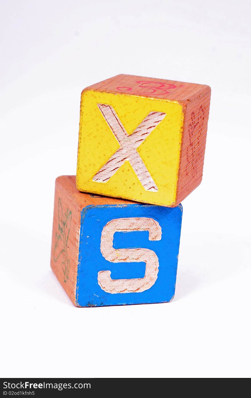 Two wooden blocks showing the letters X and S. Two wooden blocks showing the letters X and S