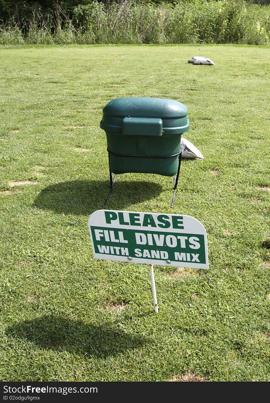 Sign indicating directions to golfers to sand divots. Sign indicating directions to golfers to sand divots