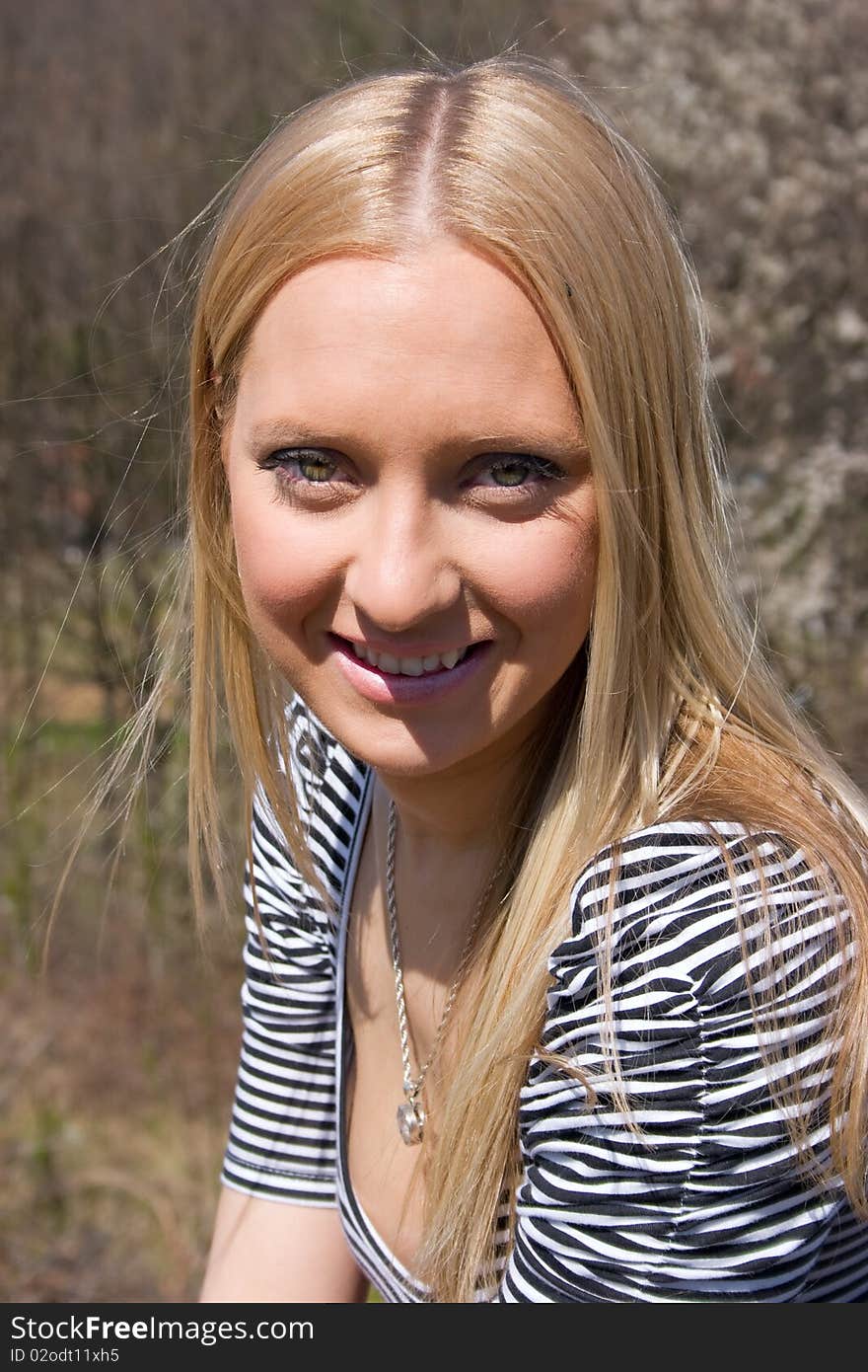 Blond girl in front of blossomed tree on early spring