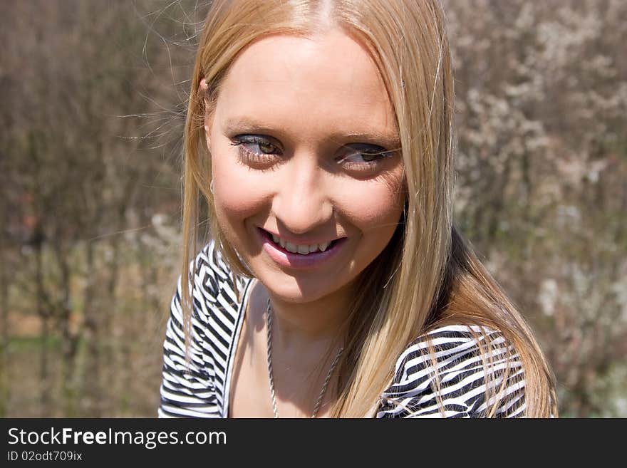 Blond girl in front of blossomed tree on early spring