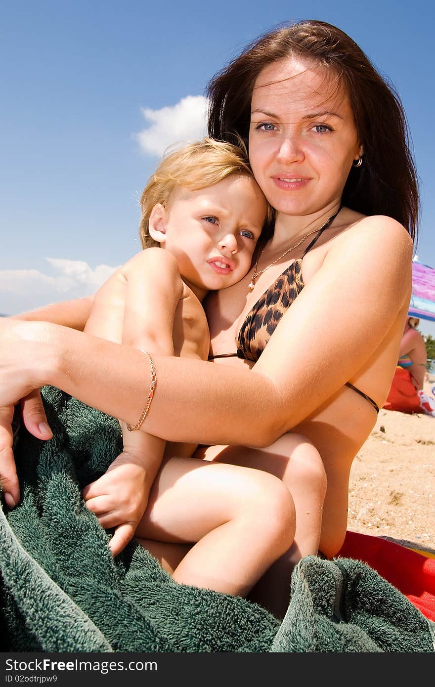 Young Mother Holding Her Son At The Beach