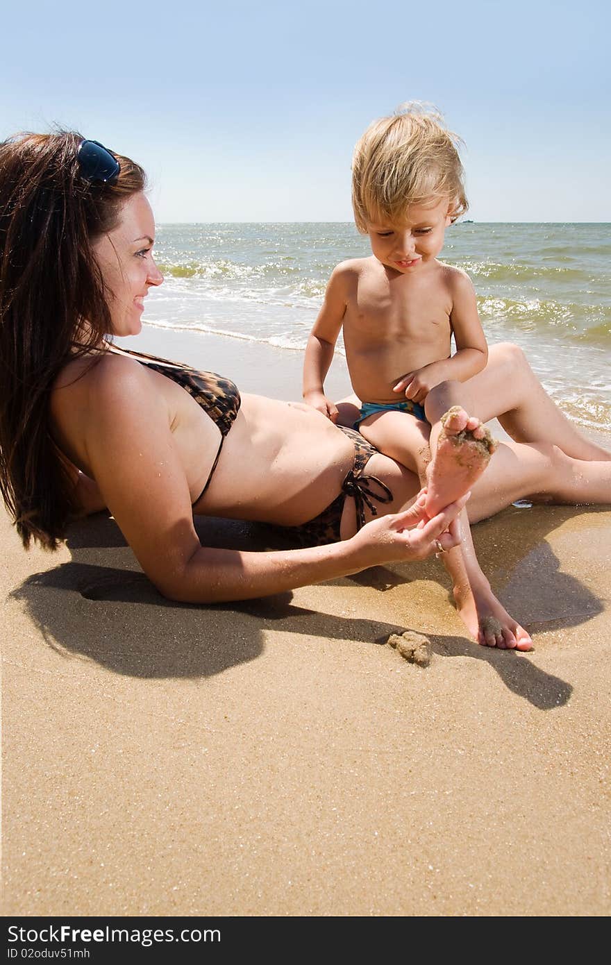 Young mother having fun with her son at the sea