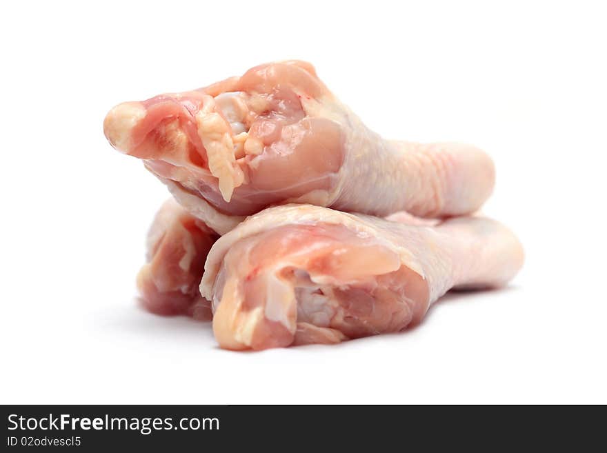 Close up of three raw chicken drumsticks isolated on white background.