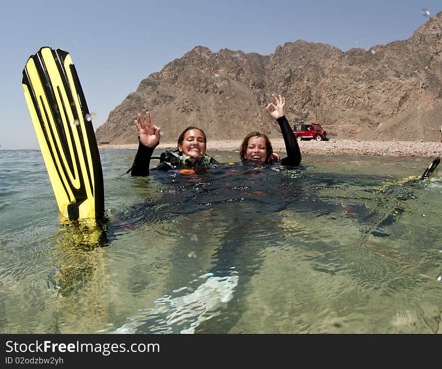 Female scuba diver swimms backwards on surface