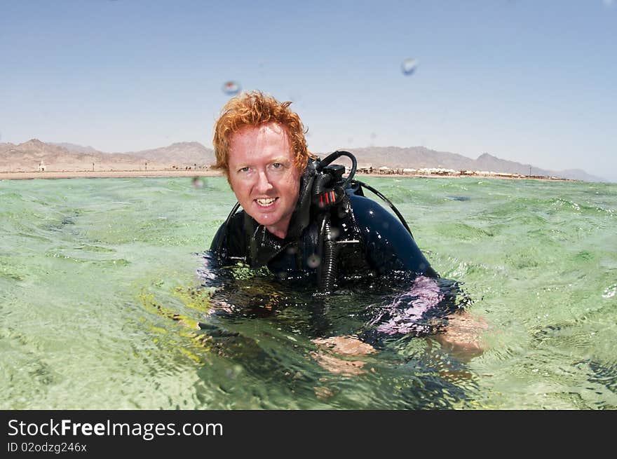 Male scuba diver on surface in red sea
