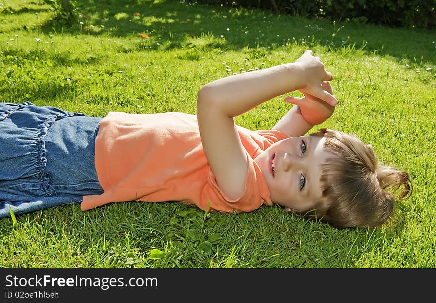 Little girl resting in the garden grass