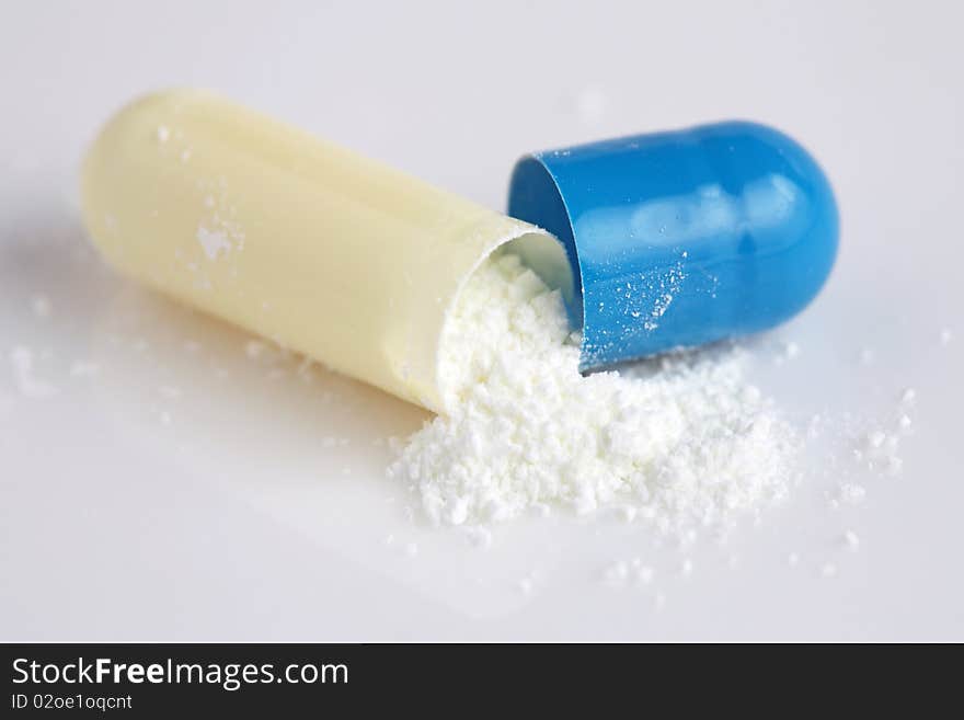 Close up of pill peeled into half with powder isolated on white background. Close up of pill peeled into half with powder isolated on white background