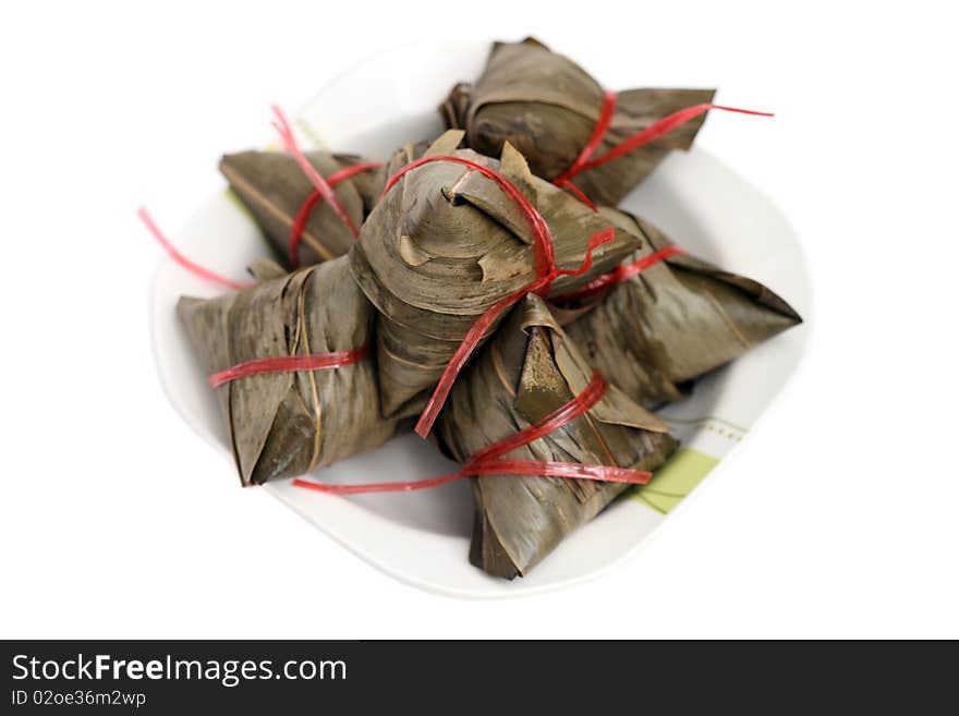 Close up of many rice dumplings on plate over white background.