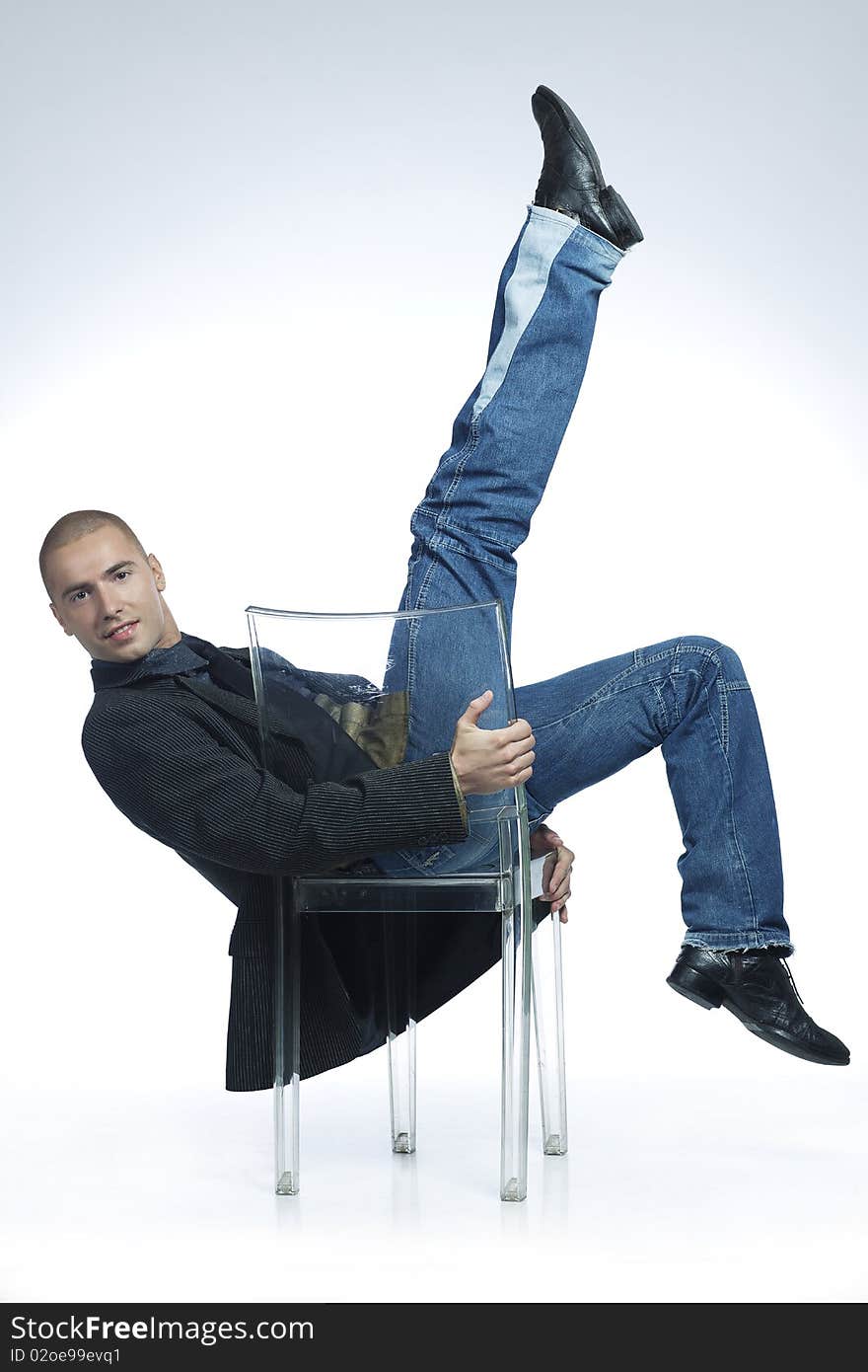 Athletic smiling young man dancing on a chair. Athletic smiling young man dancing on a chair