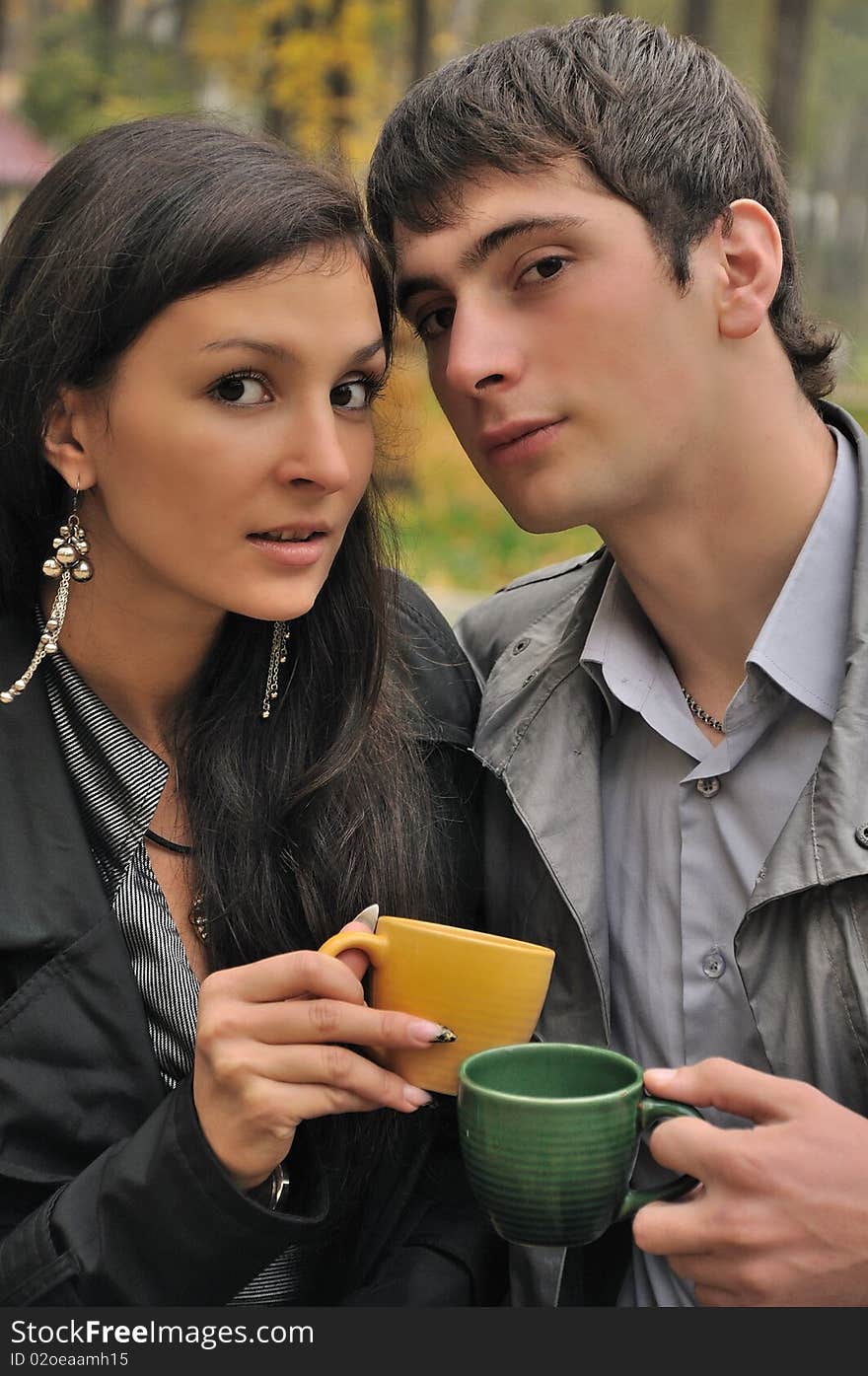 Young falling in love couple drinks tea at the city park. Young falling in love couple drinks tea at the city park