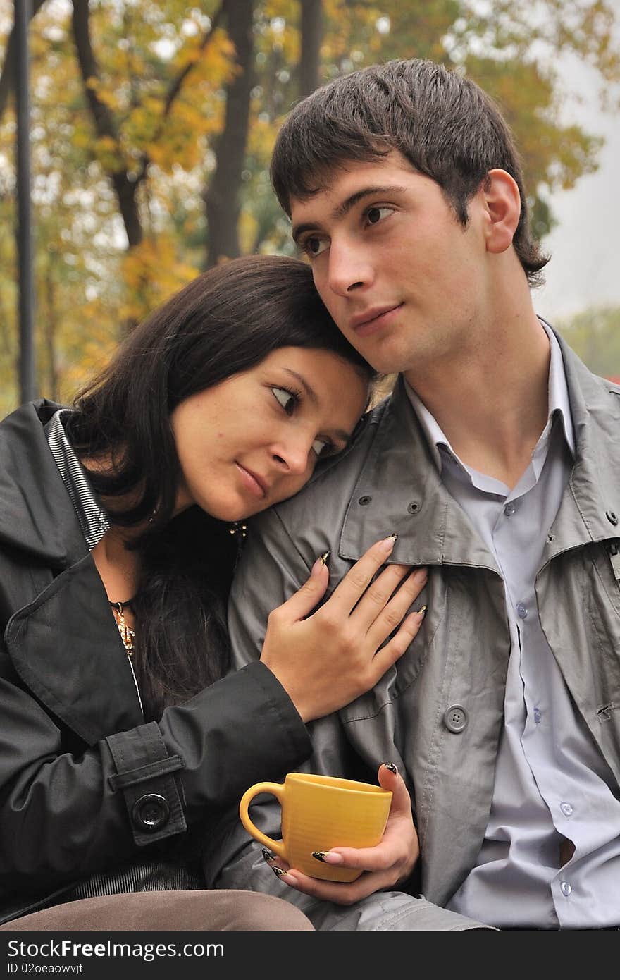 Young falling in love couple drinks tea at the city park. Young falling in love couple drinks tea at the city park