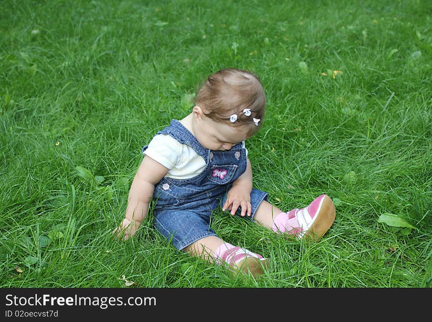 The girl sits on a grass