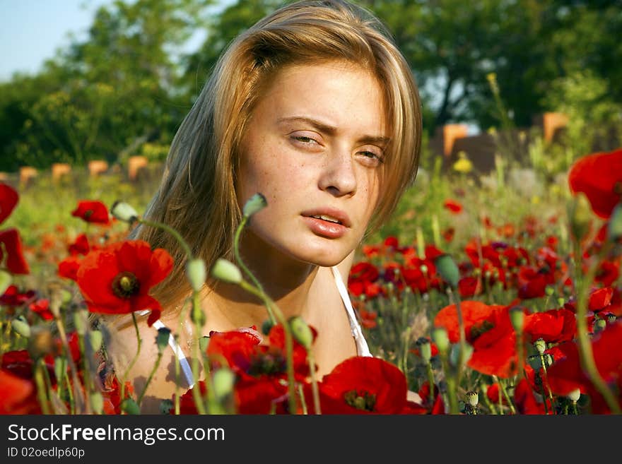 Portrait of a beautiful girl in the red poppies