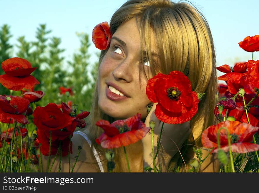 Portrait of a beautiful girl in the red poppies