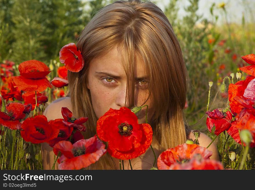 Portrait of a beautiful girl in the red poppies