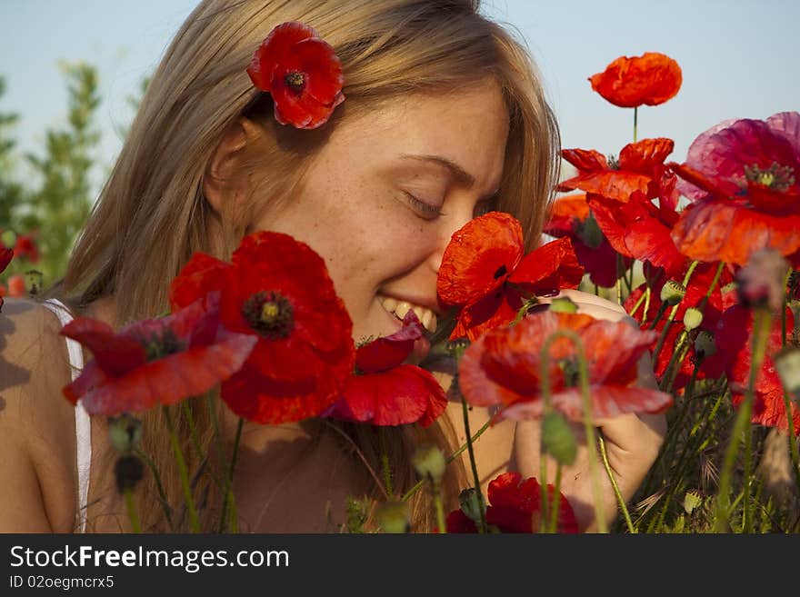 Portrait of a beautiful girl in the red poppies