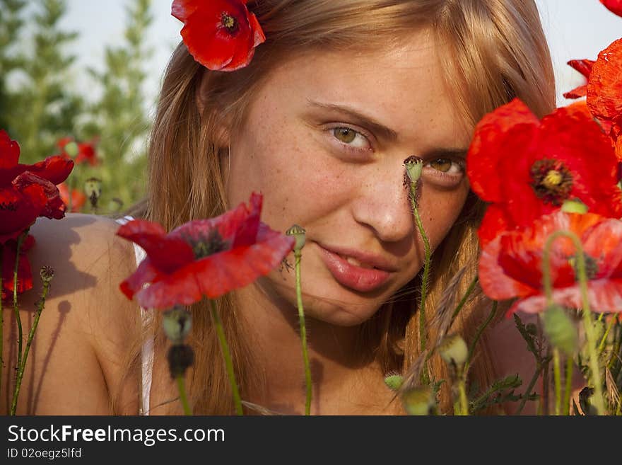 Portrait of a beautiful girl in the red poppies