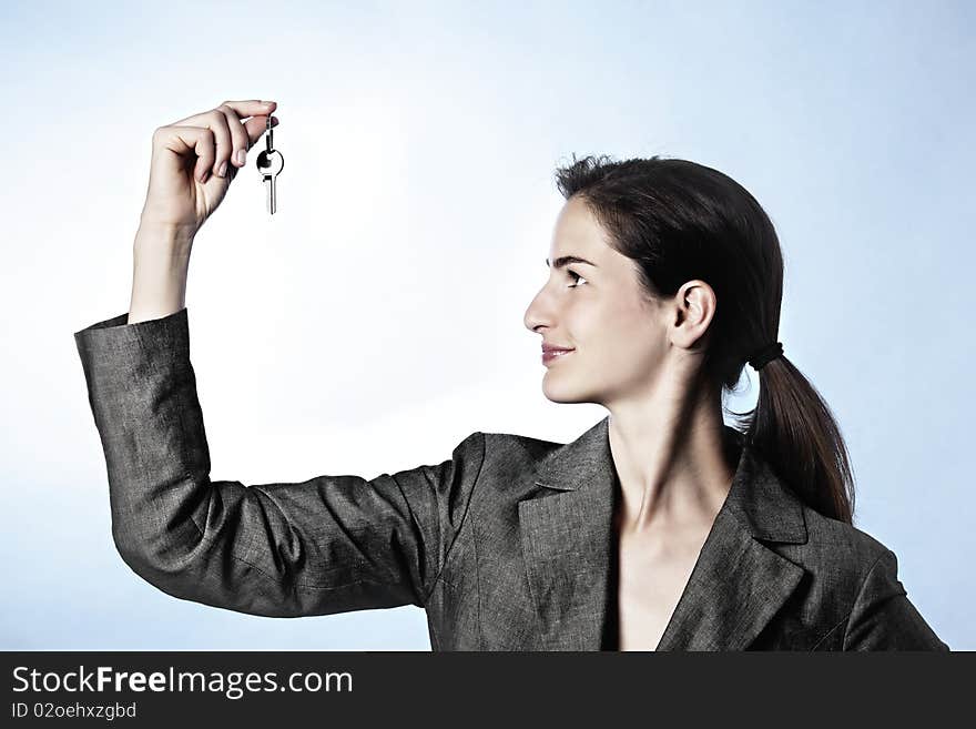 Profile of woman holding key between fingers