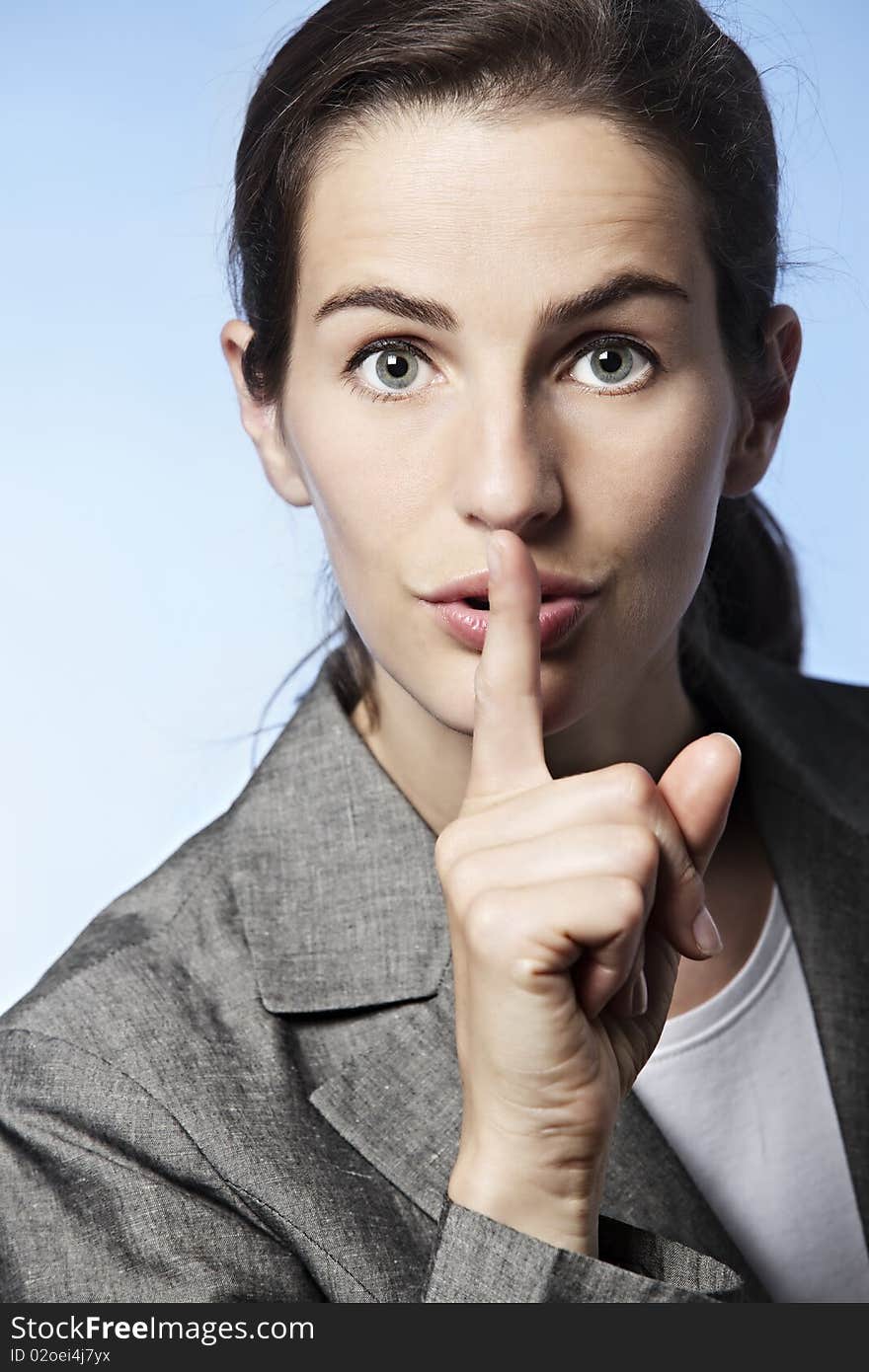 Close-up of business woman in grey suit gesturing silence. Close-up of business woman in grey suit gesturing silence.