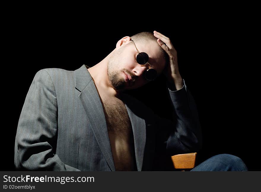 Portrait of bristly man in coat in the dark