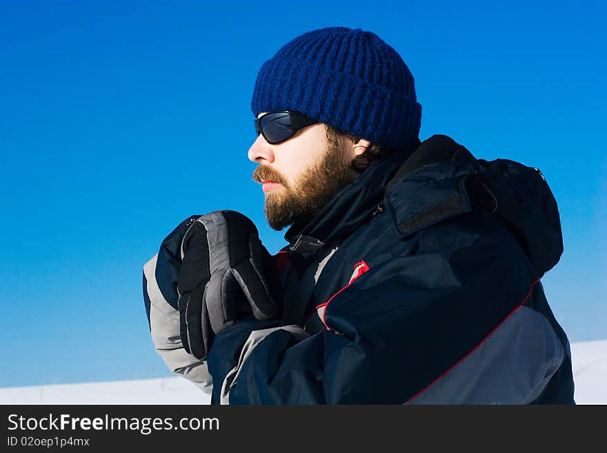 Portrait of handsome skier in the snowy field