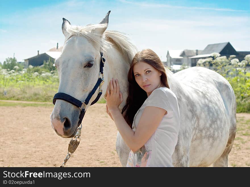 Beautiful woman and white horse at rural area. Beautiful woman and white horse at rural area