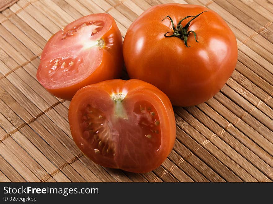 Ripe tomatoes on bamboo pad