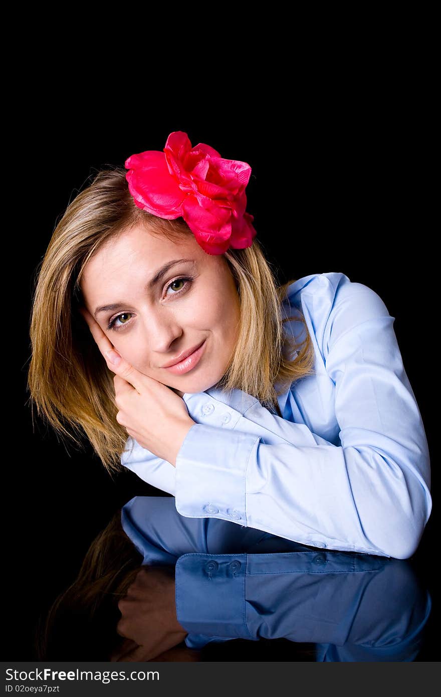 Blissful, serene, paceful female in blue shirt and with flower in her hairs, studio shoot isolated on black. Blissful, serene, paceful female in blue shirt and with flower in her hairs, studio shoot isolated on black