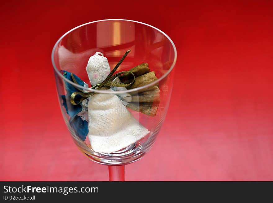 Pour feliciter (happy new year) - angel puppet in a glass on a red background. Pour feliciter (happy new year) - angel puppet in a glass on a red background