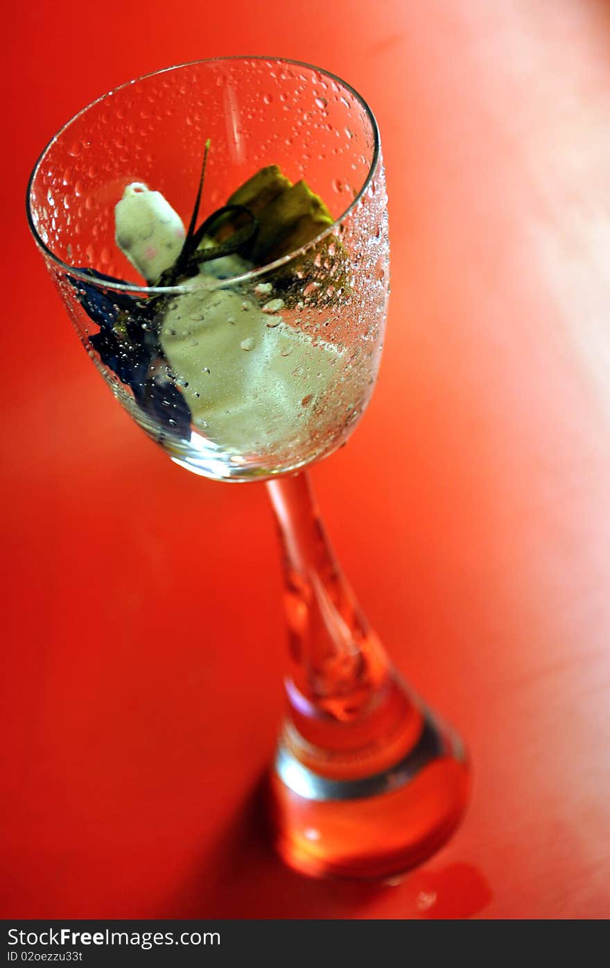 Pour feliciter (happy new year) - angel puppet in a glass on a red background. Pour feliciter (happy new year) - angel puppet in a glass on a red background