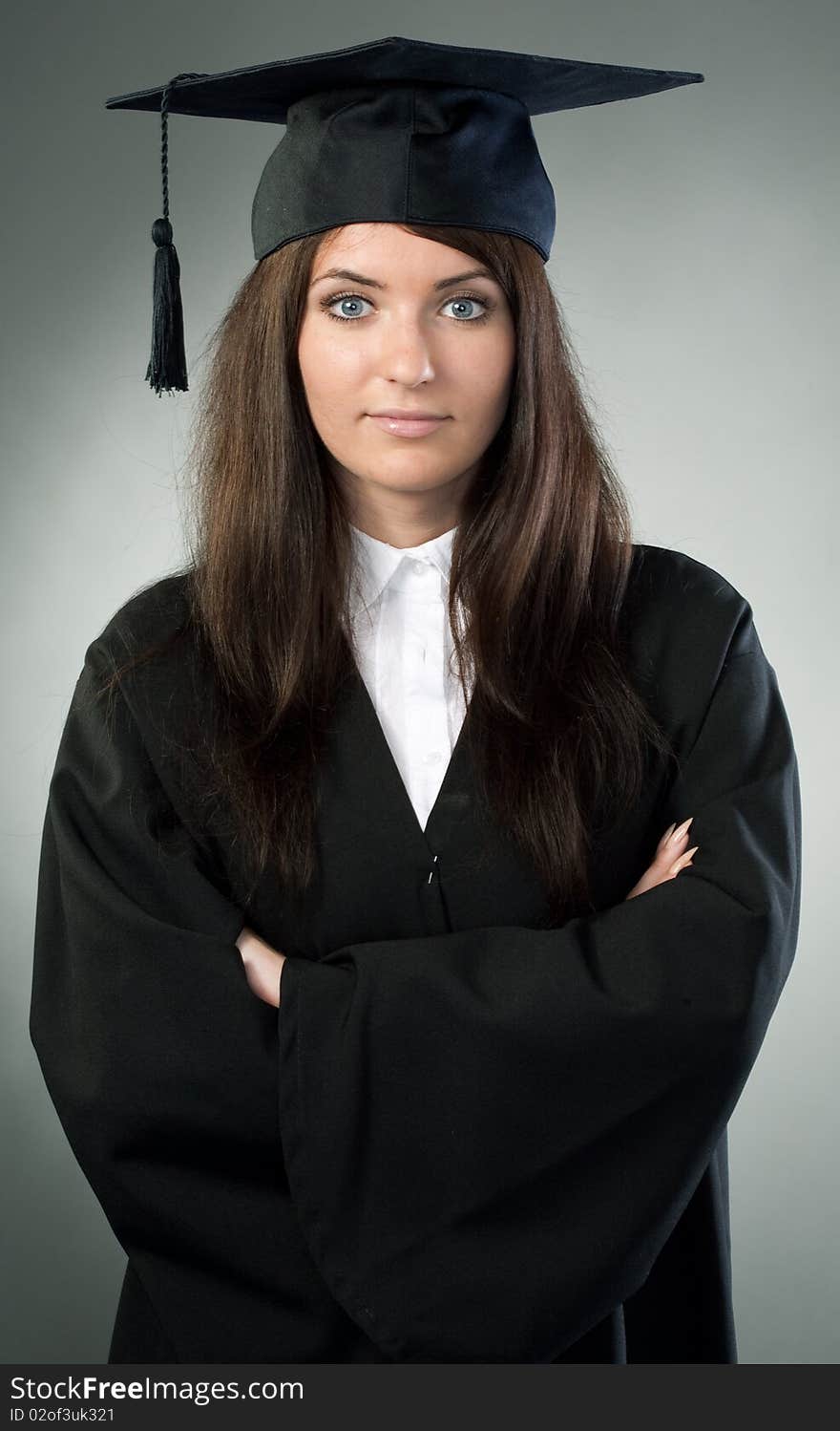 Young beauty graduate woman on gray background