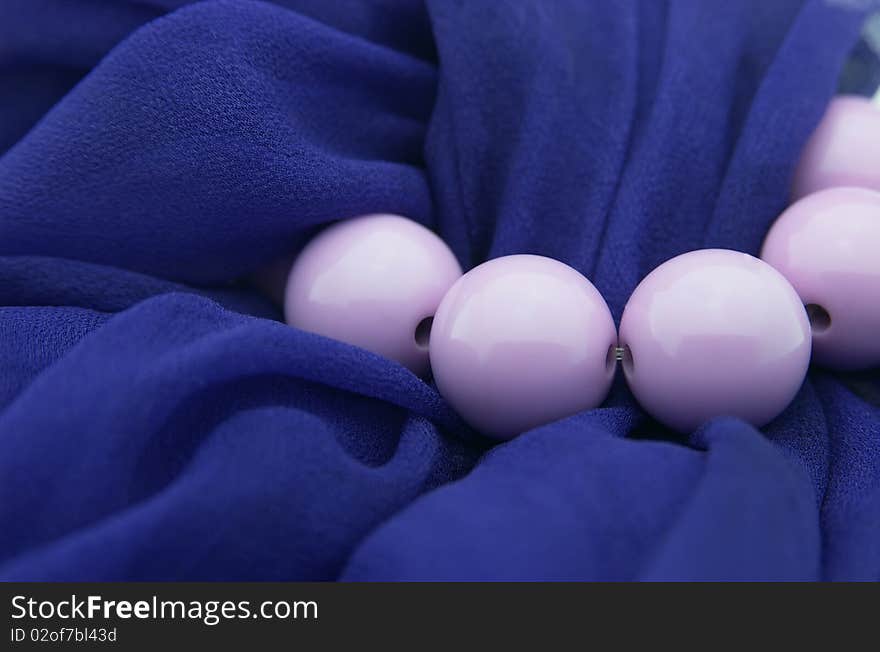 Lilac beads against dark blue scarf, close up. Lilac beads against dark blue scarf, close up