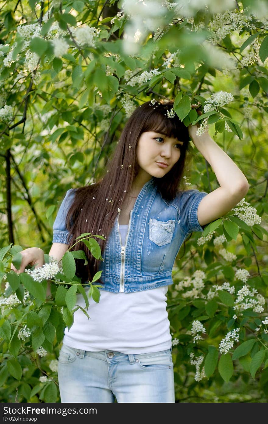 Girl standing near lilac in blossom