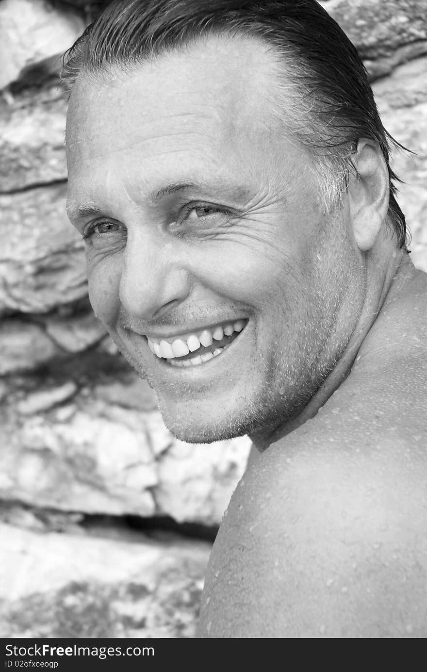 A black and white portrait photo of a handsome mature man with stubble and slicked back hair. A black and white portrait photo of a handsome mature man with stubble and slicked back hair.