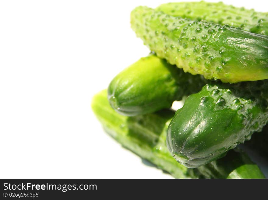 Heap made with cucumbers on a side of image on white background. Heap made with cucumbers on a side of image on white background