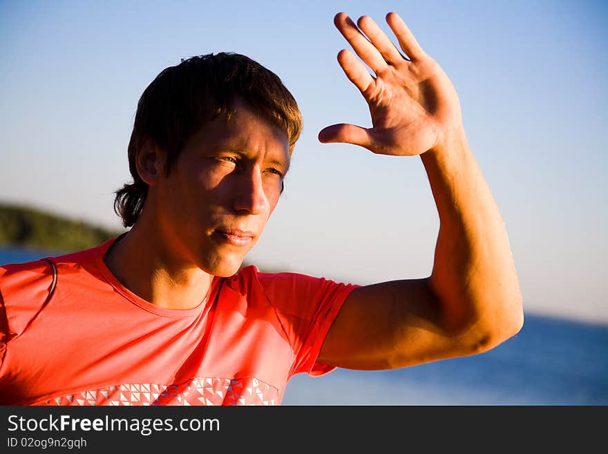 Portrait of  beautiful young men in sports clothing at sunset on the beach. Portrait of  beautiful young men in sports clothing at sunset on the beach