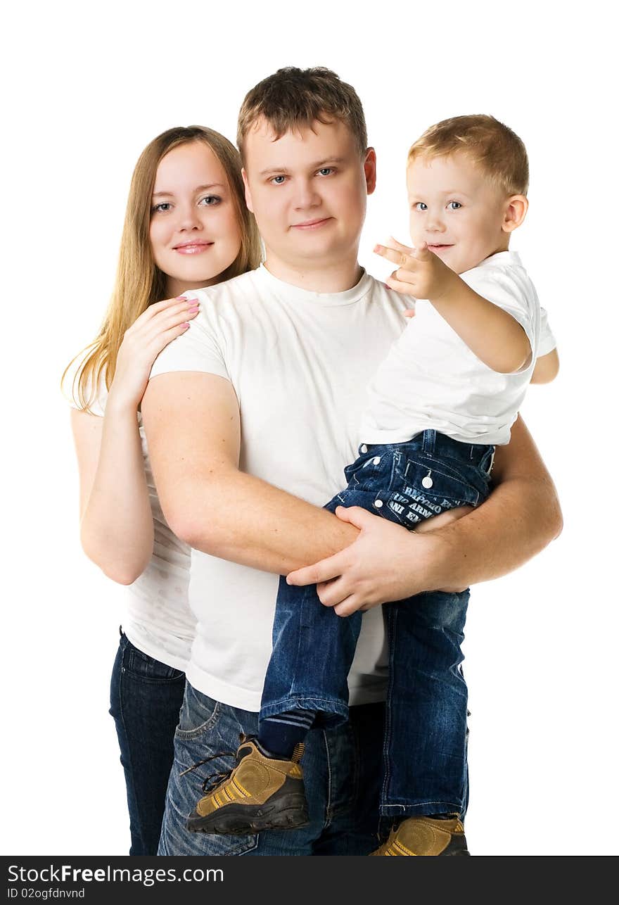 Young parents with son on hands in white T-shirts stand isolated on white,  kid points a finger in the camera. Young parents with son on hands in white T-shirts stand isolated on white,  kid points a finger in the camera