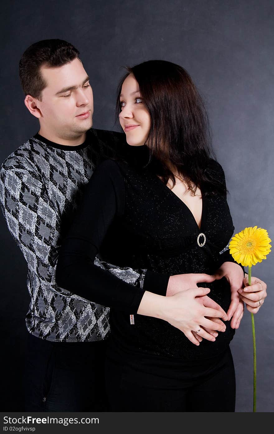 Pregnant couple posing, isolated on dark background. Pregnant couple posing, isolated on dark background