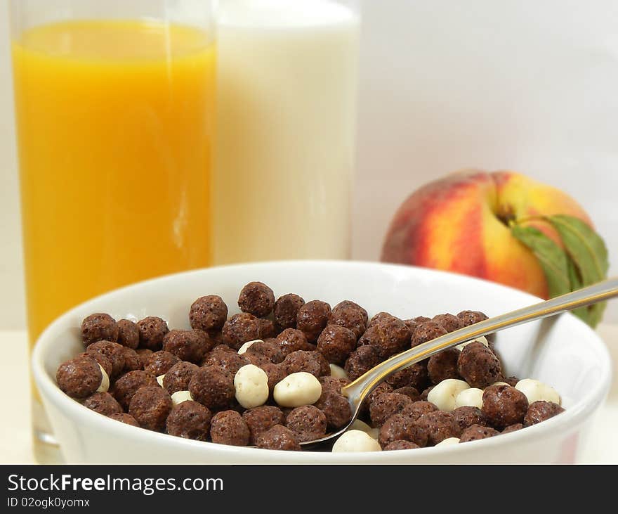 View of the Corn Flakes, chocolate balls, juice and milk,peach. View of the Corn Flakes, chocolate balls, juice and milk,peach