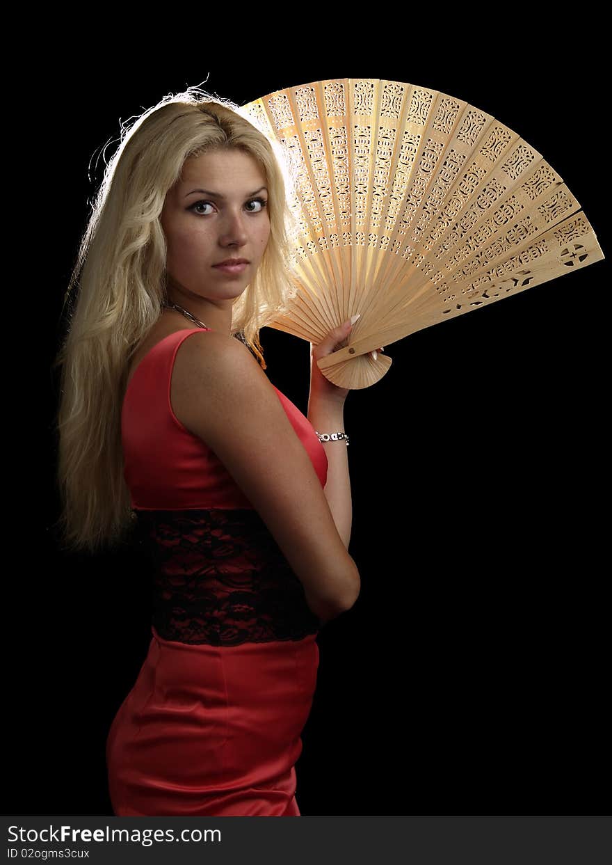 Blonde young lady in red dress with fan on black background. Blonde young lady in red dress with fan on black background