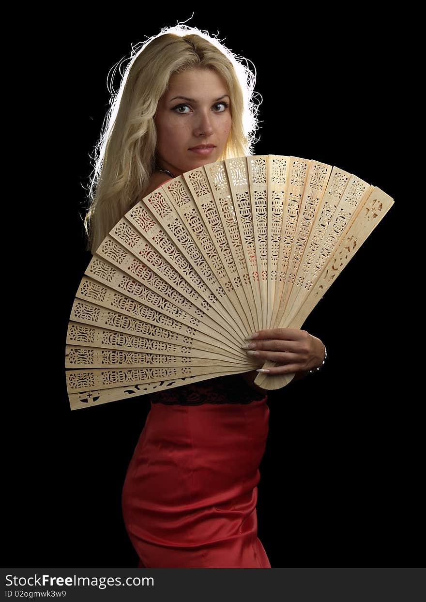 Blonde young lady in red dress with fan on black background. Blonde young lady in red dress with fan on black background