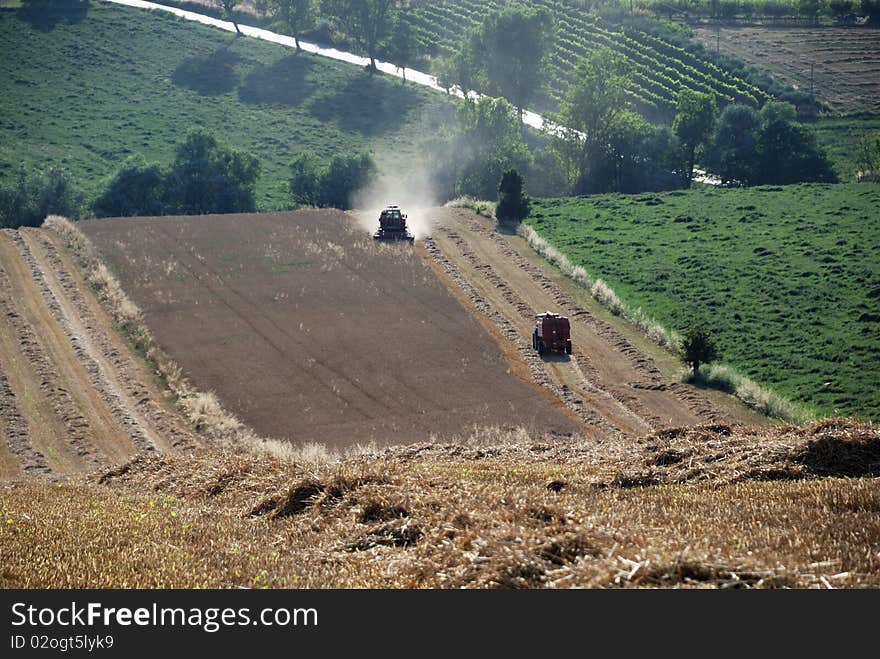 Harvest machine on grain field with meadows on background. Harvest machine on grain field with meadows on background